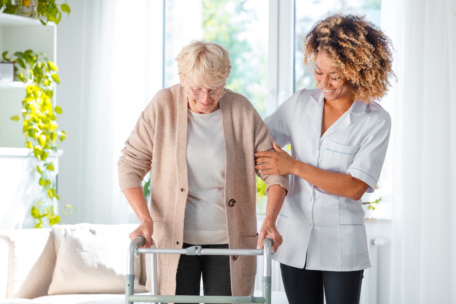 Caregiver helping hospice patient in walker.