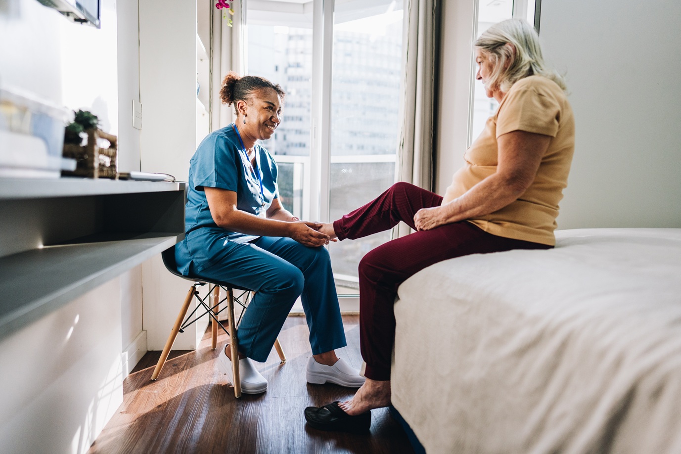 Caregiver helps patient with foot care